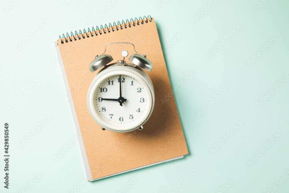 clock on notebook on the table clock on notebook on the table