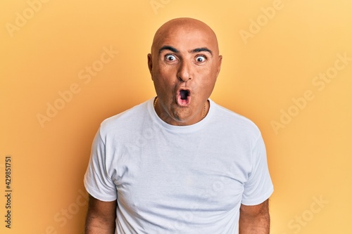 Mature middle east man wearing casual white tshirt afraid and shocked with surprise expression, fear and excited face. © Krakenimages.com