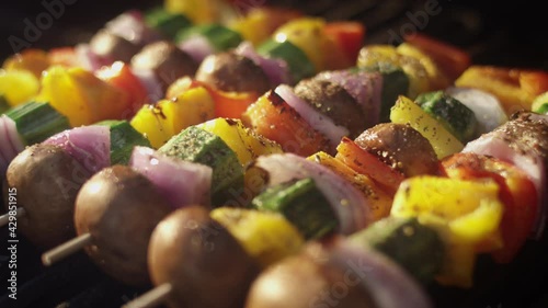 Panning shot across colorful vegetables smoking on the grill