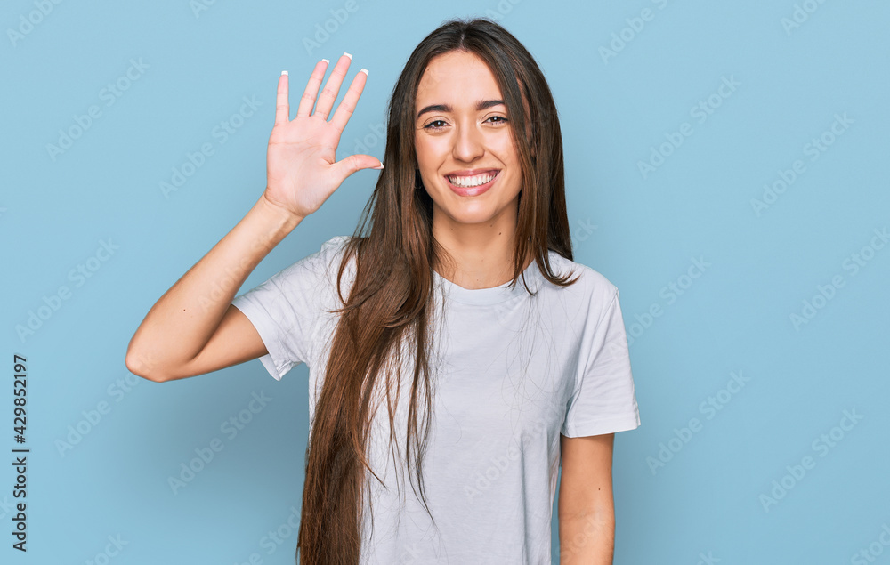 Young hispanic girl wearing casual white t shirt showing and pointing up with fingers number five while smiling confident and happy. Young hispanic girl wearing casual white t shirt showing and pointing up with fingers number five while smiling confident and happy.