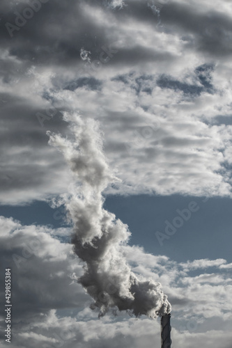 The chimney in deep blue heavy sky of a thermal power plant, the smoke extracted in the production process from pipe. Environment. Pollution..