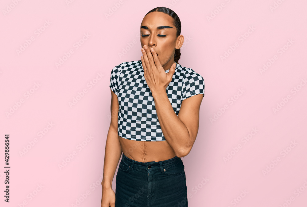 Hispanic transgender man wearing make up and long hair wearing modern clothes bored yawning tired covering mouth with hand. restless and sleepiness. Hispanic transgender man wearing make up and long hair wearing modern clothes bored yawning tired covering mouth with hand. restless and sleepiness.