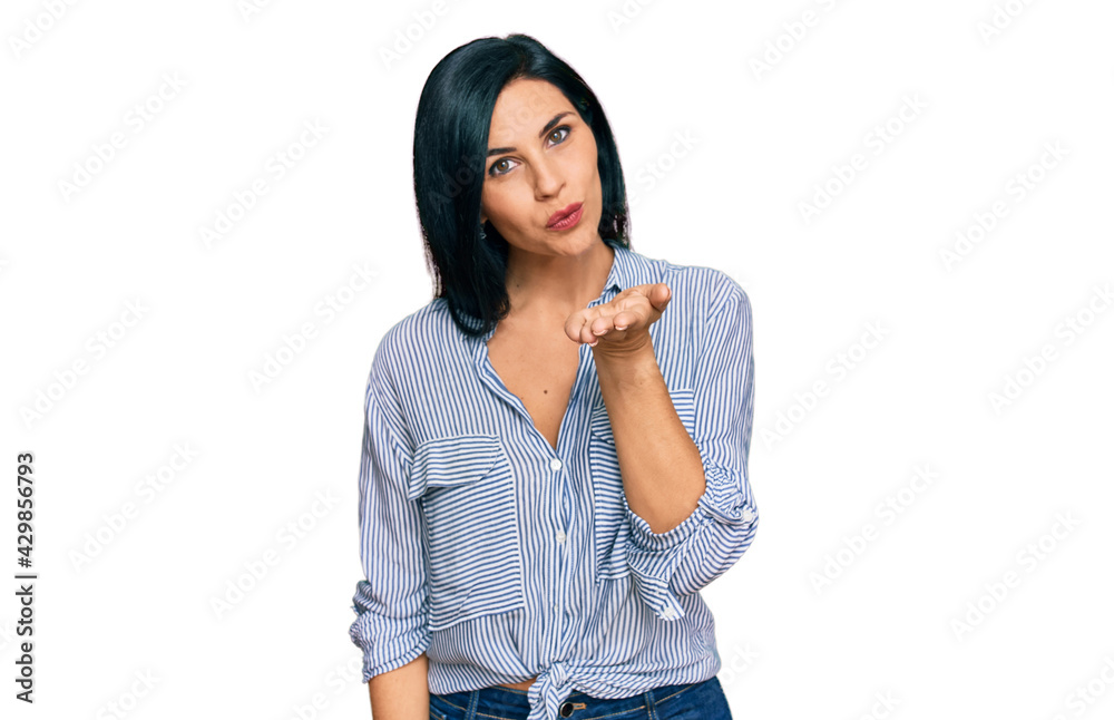 Young caucasian woman wearing casual clothes looking at the camera blowing a kiss with hand on air being lovely and sexy. love expression. Young caucasian woman wearing casual clothes looking at the camera blowing a kiss with hand on air being lovely and sexy. love expression.