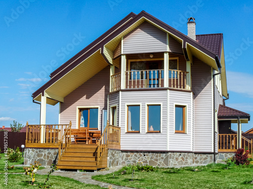 Classical cozy country house with tiled roof and chimney in springtime.