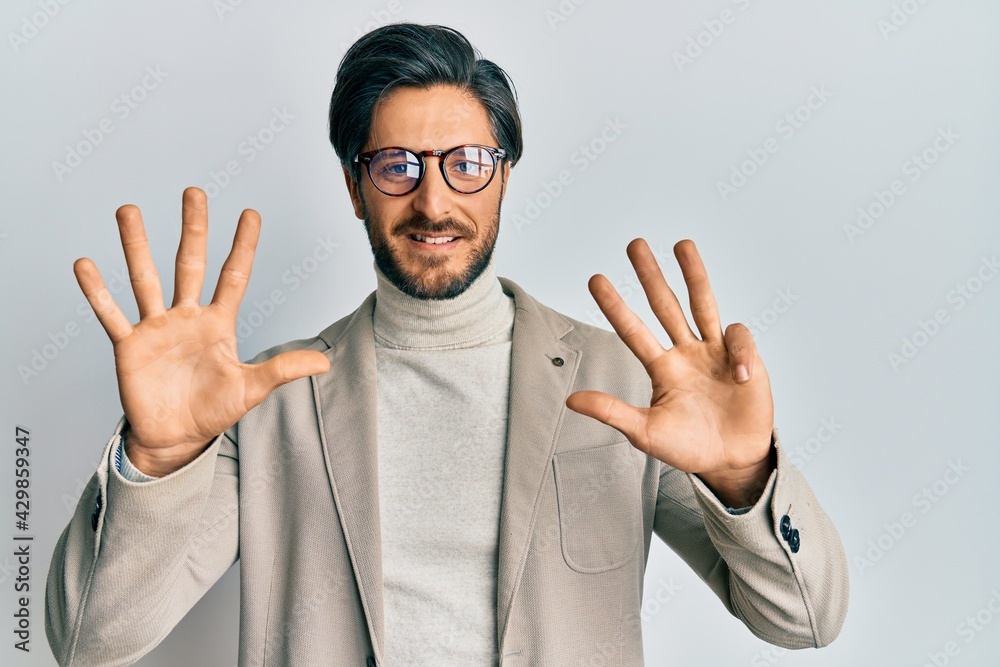 Young hispanic man wearing business jacket and glasses showing and pointing up with fingers number nine while smiling confident and happy. Young hispanic man wearing business jacket and glasses showing and pointing up with fingers number nine while smiling confident and happy.