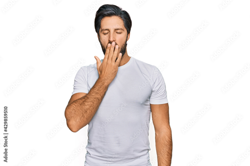 Young hispanic man wearing casual white t shirt bored yawning tired covering mouth with hand. restless and sleepiness. Young hispanic man wearing casual white t shirt bored yawning tired covering mouth with hand. restless and sleepiness.