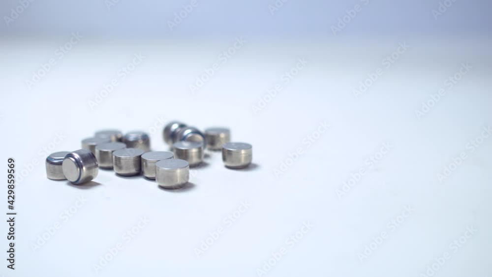 Close up on button battery. The batteries were scattered on the table. Truck shot from left to right. Close up on button battery. The batteries were scattered on the table. Truck shot from left to right.