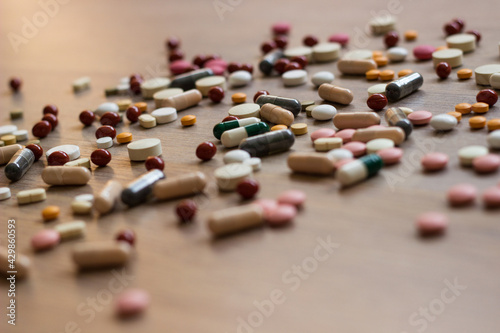 A photo of different medicinal drugs, tablets and pills on wooden background