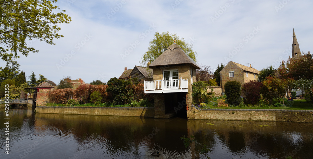 Fototapeta premium The river Ouse at Godmanchester with old boathouse and church spire.