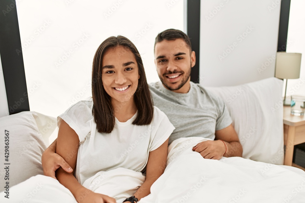 Young latin couple smiling happy hugging on the bed at home. Young latin couple smiling happy hugging on the bed at home.