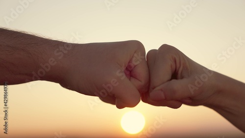 teamwork concept at sunset in the sky. fist to fist commit solidarity a respect and brotherhood gesture. lifestyle business team hands fists close-up. people of different partnership friendship photo