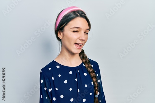 Young brunette girl wearing elegant look winking looking at the camera with sexy expression, cheerful and happy face.