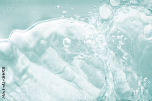 Photos Blue green splashing cosmetic moisturizer, micellar water,  toner, or emulsion abstract background