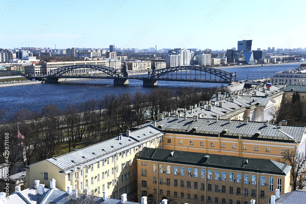 Russia. St. Petersburg, April, 2021. View of the embankment and Bridge over the Neva River in St. Petersburg on a sunny day in early spring.