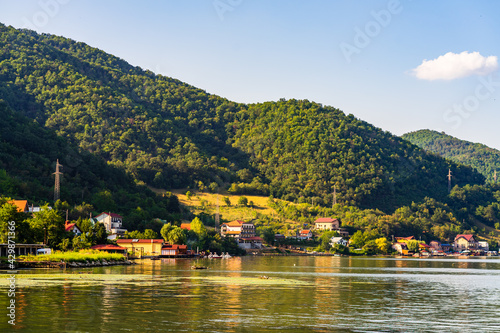 Beautiful view of Danube Gorge (Iron Gates) with buildings and mountain forests under a clear sky photo