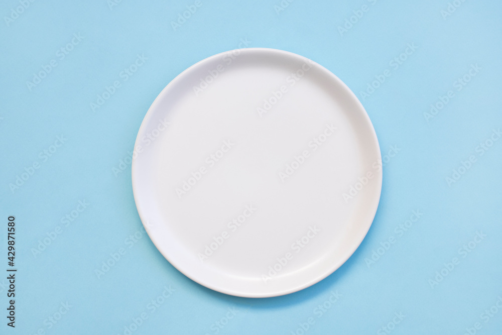 white empty plate on blue background, top view white empty plate on blue background, top view