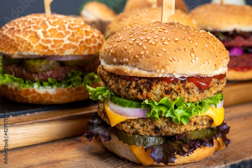 Tasty vegetarian cheeseburgers and hamburgers with round patties or burgers made from grains, vegetables and legumes