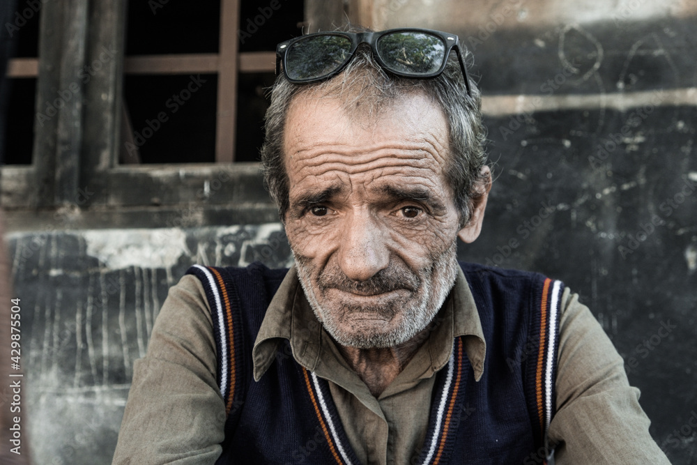Fototapeta premium Portrait of a Georgian man. The worker takes a break and rests in the air. The expressive eyes of a wise man, the tired look of an elderly man. Day. Fall. Georgia.