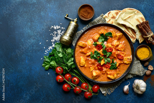 Chicken tikka masala - traditional dish of indian cuisine in a black bowl.Top view with copy space. photo