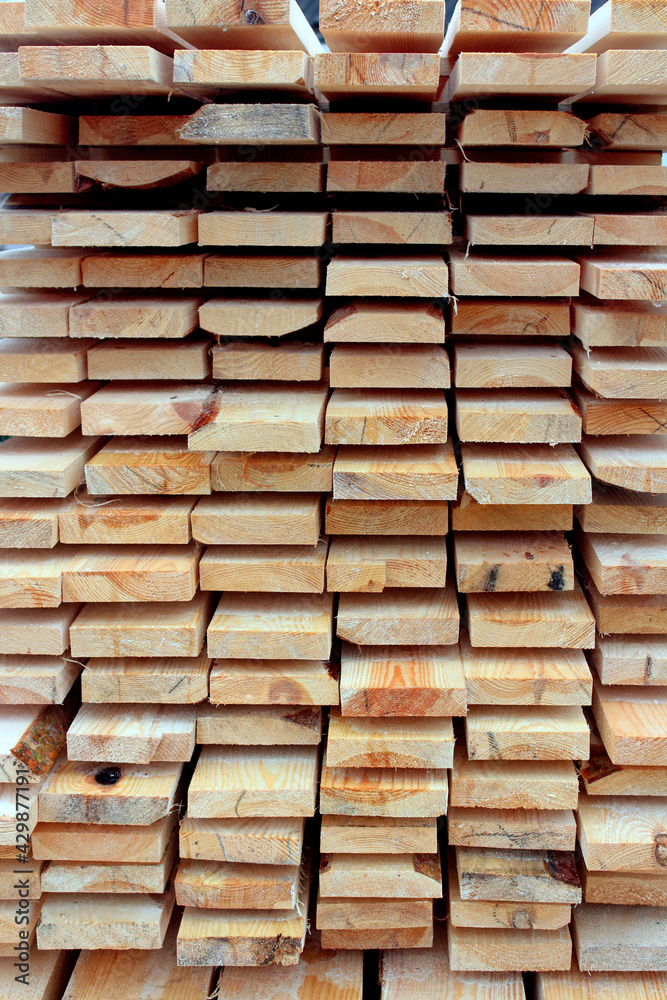 A bunch of planks stacked one-on-one. Background of wooden board. Natural wood texture A bunch of planks stacked one-on-one. Background of wooden board. Natural wood texture