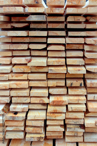 A bunch of planks stacked one-on-one. Background of wooden board. Natural wood texture