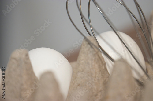 wire wisk on top of eggs in carton photo