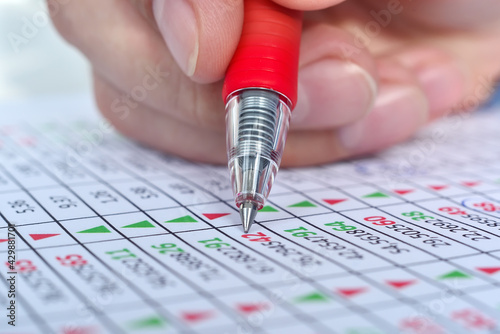Canvas Print Hand with pen correction stock market report with stock data