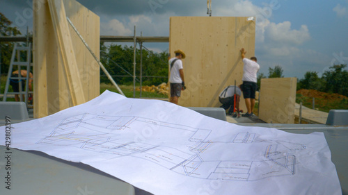 CLOSE UP: Floor plans lie on the workbench at a construction site in countryside