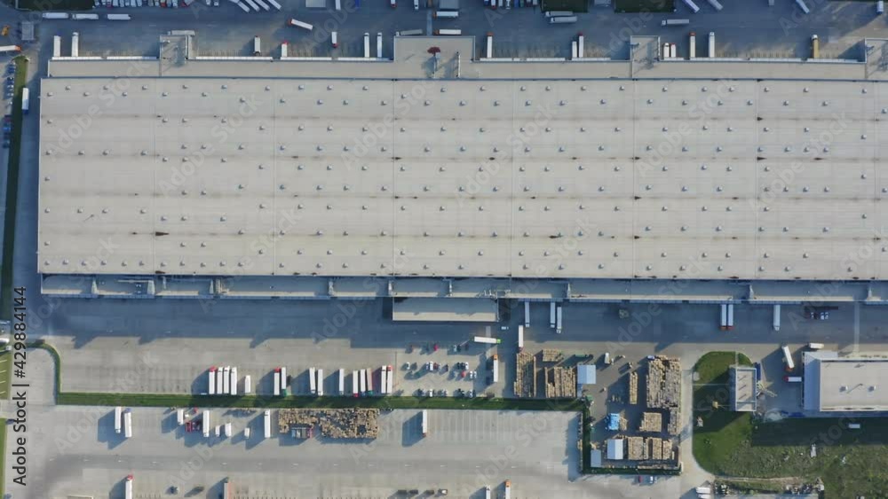 Logistics park with warehouse and loading hub. Semi-trailers trucks stand at ramps and wait for load and unload goods. Aerial top down view Logistics park with warehouse and loading hub. Semi-trailers trucks stand at ramps and wait for load and unload goods. Aerial top down view