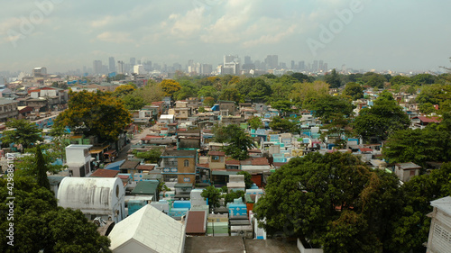 The city of Manila, the capital of the Philippines and Manila North Cemetery, top view. Modern buildings in the city center.