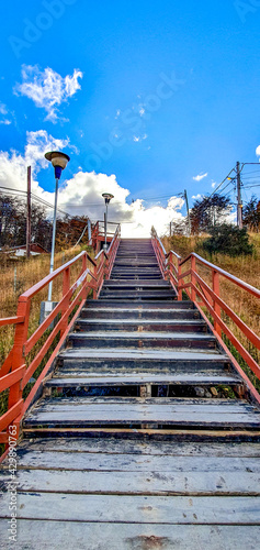 old  wooden  staircase  with  view  of  a  sky  with  clouds