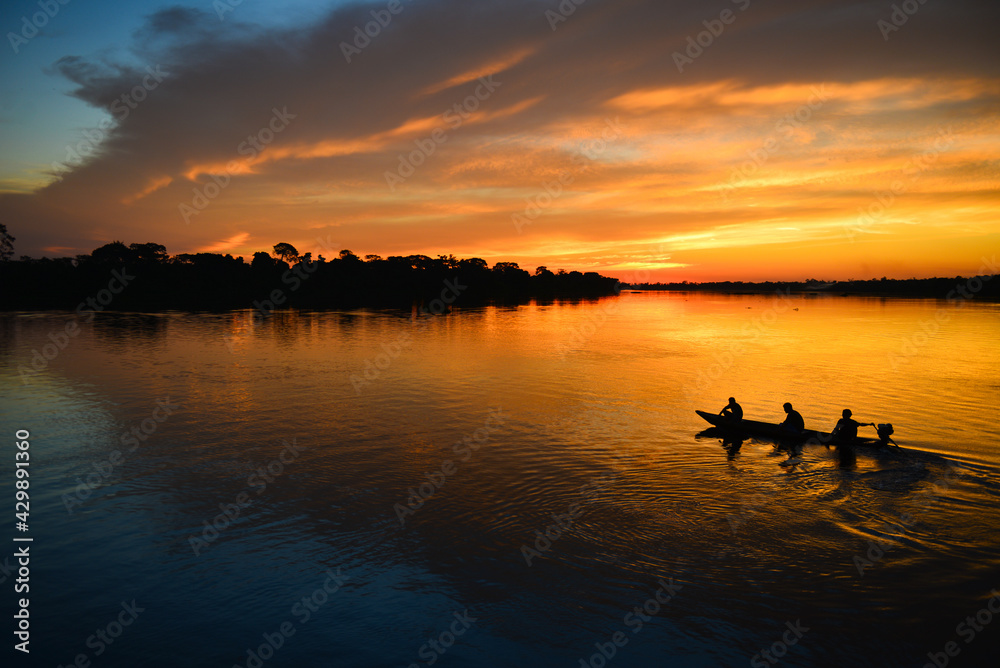 A small motorized canoe on the Guaporé - Itenez river during sunset, Ricardo Franco village, Vale do Guaporé Indigenous Land, Rondonia, Brazil, on the border with Bolivia