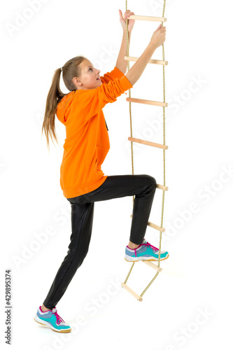 Teenage girl climbing rope ladder. Isolated over white background.