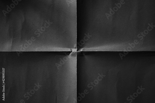 Black paper folded in four fraction background photo