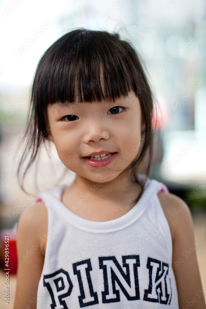 Portrait of cute little Asian girl toddler smiling and looking at the camera, bokeh blur outdoor background. Portrait of cute little Asian girl toddler smiling and looking at the camera, bokeh blur outdoor background.