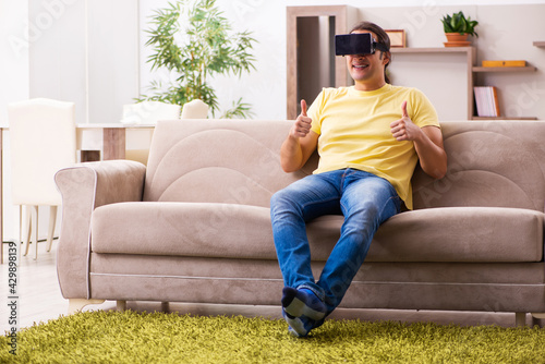 Young man student with virtual glasses at home