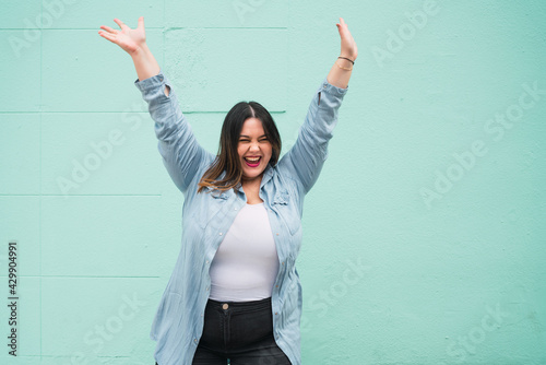 Young plus size woman celebrating victory.