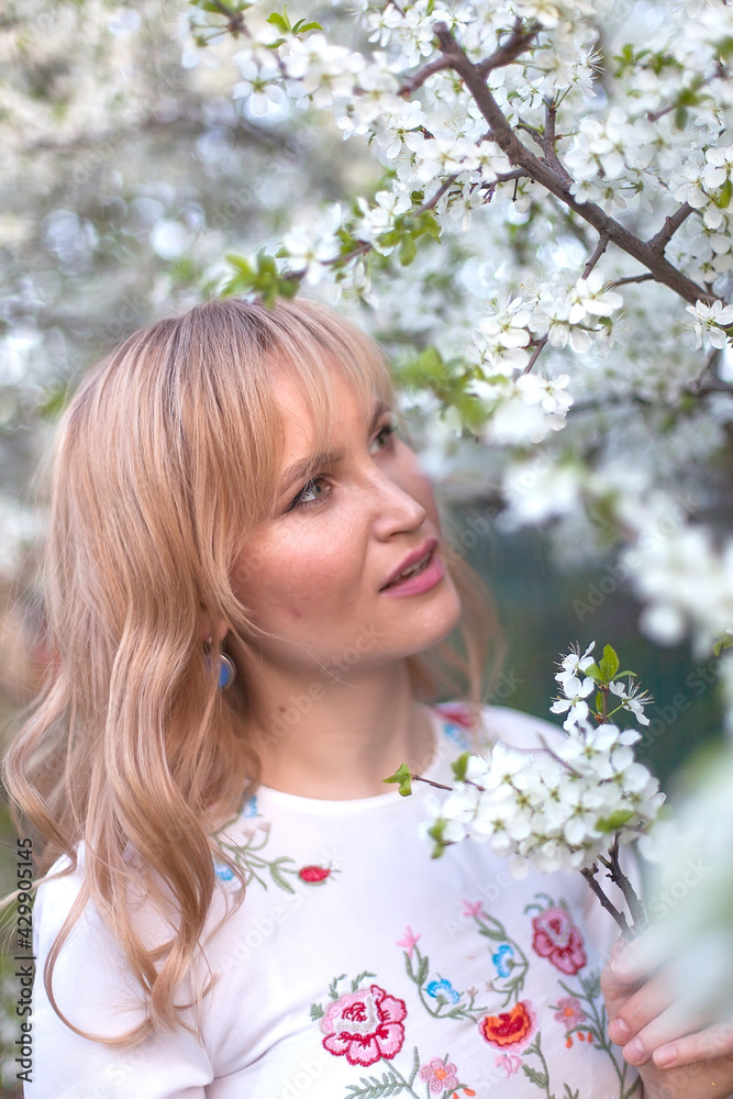Young long-haired woman in the garden blooming in spring. Young long-haired woman in the garden blooming in spring.