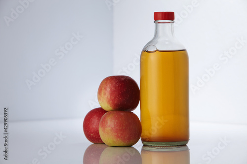 apple cider vinegar and fresh apples on white background