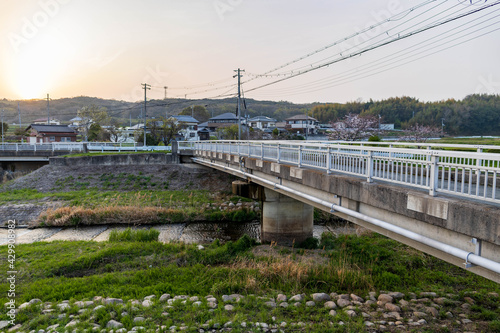 Empty bridge over quiet stream in rural japanese neighborhood at sunset