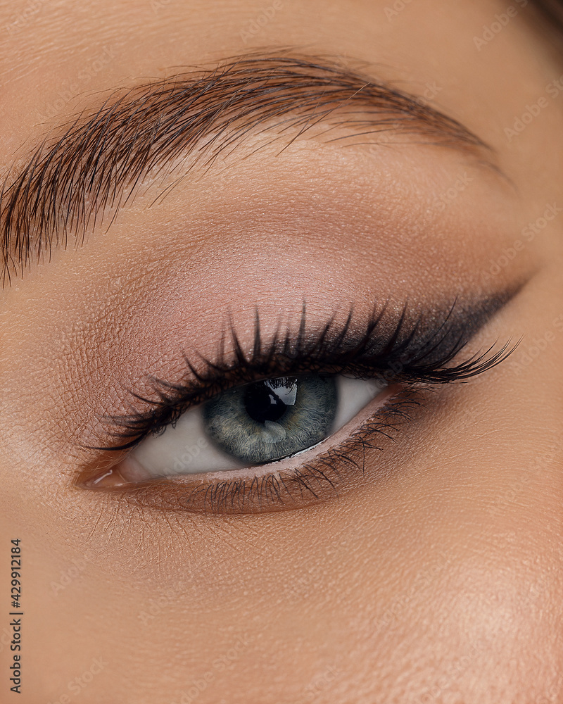 Beautiful macro shot of female eye make-up in smoky eyes style and arrow. Blue eye. Creative make-up. Perfect shape make-up and long lashes. Cosmetics. Beautiful eyes make-up. Close-up Beautiful macro shot of female eye make-up in smoky eyes style and arrow. Blue eye. Creative make-up. Perfect shape make-up and long lashes. Cosmetics. Beautiful eyes make-up. Close-up