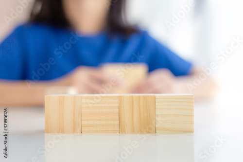 Four blank wooden block cubes on the table with blurred kid girl background for mockup, template, banner concepts