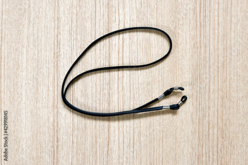 leather black eyeglasses strap on a wooden background