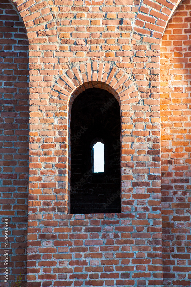 Shaped window in ancient brick wall. A fragment of old Smolensk Kremlin fortress. Shaped window in ancient brick wall. A fragment of old Smolensk Kremlin fortress.
