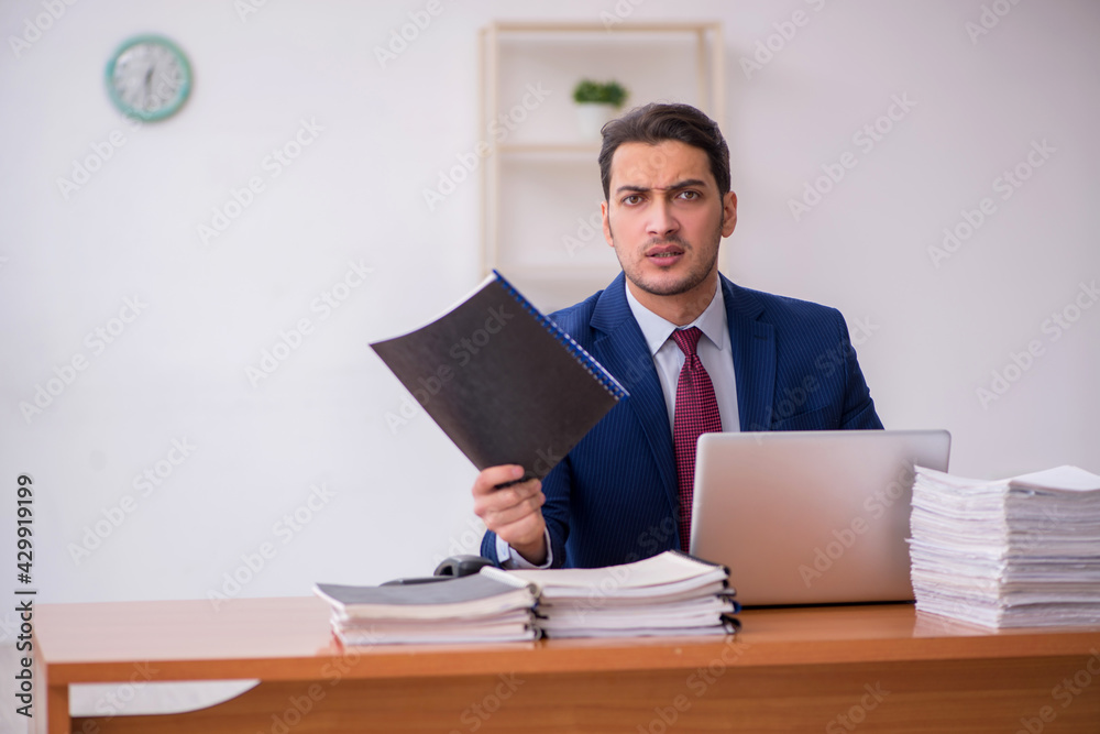 Young businessman and too much work in the office