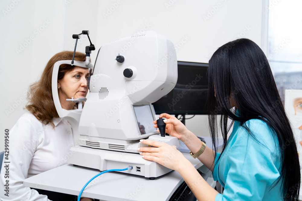 Brunette female opthometrist is diagnosing senior woman on special modern equipment. Up-to-date clinic for healthy eyes. Closeup. Brunette female opthometrist is diagnosing senior woman on special modern equipment. Up-to-date clinic for healthy eyes. Closeup.