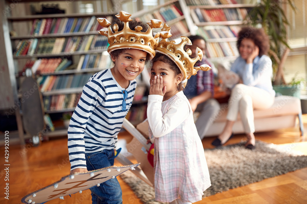 The kids are whispering some secrets while playing at home. Family, together, love, playtime