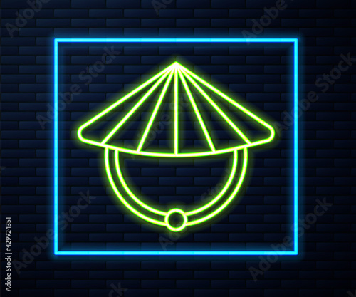 Glowing neon line Asian or Chinese conical straw hat icon isolated on brick wall background. Vector