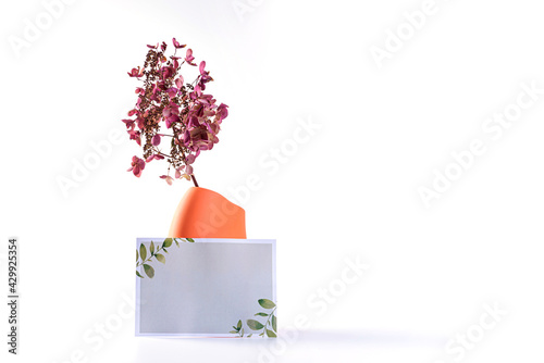 ceramic vase with dried flowers and a poster for text isolated on a light background