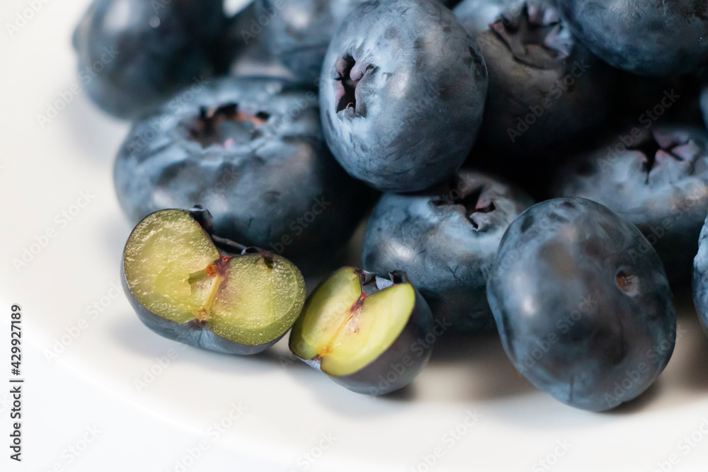 Halved blueberry in selective focus against a heap of blueberries. Close-up of an antioxidant superfood. Halved blueberry in selective focus against a heap of blueberries. Close-up of an antioxidant superfood.
